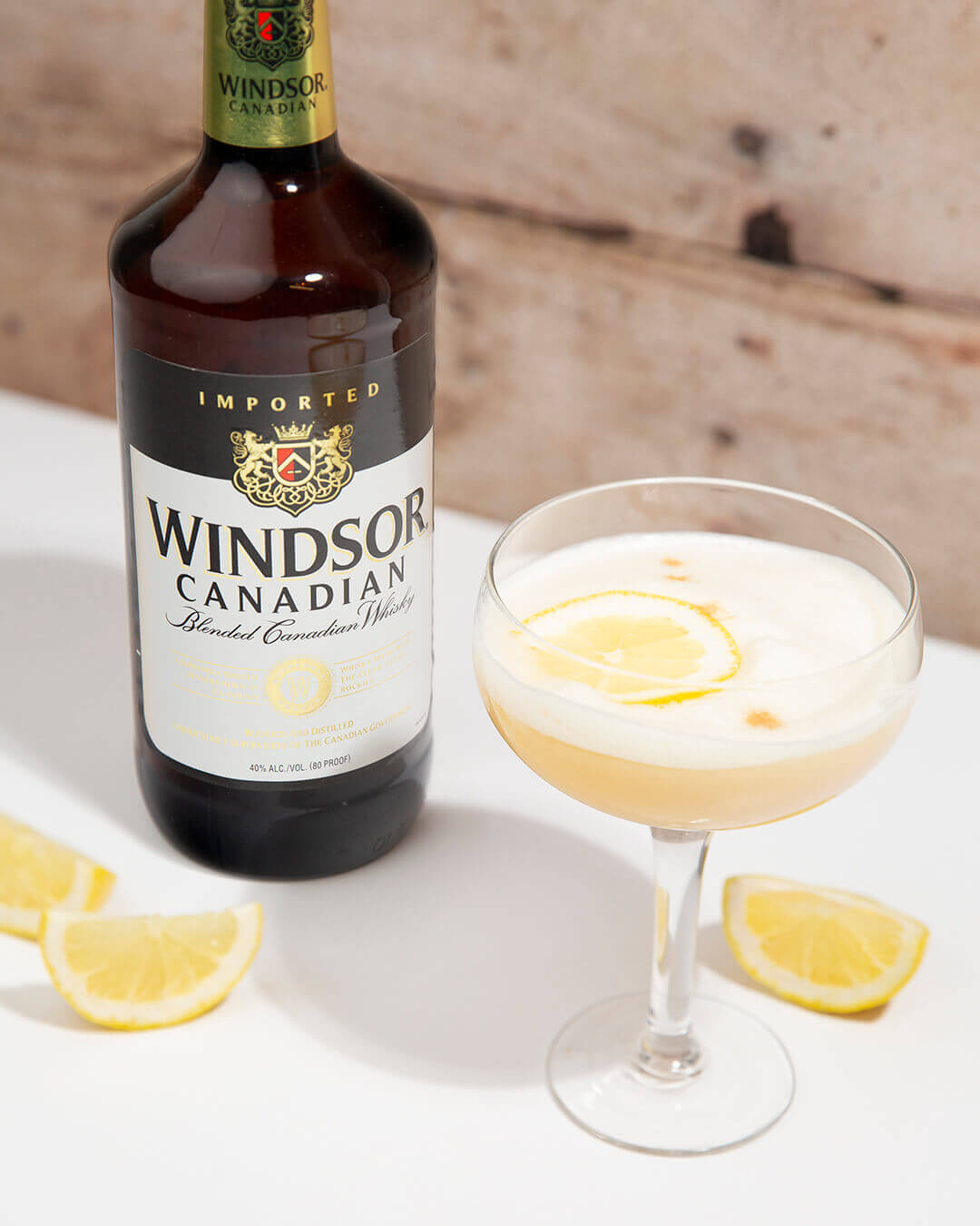 Windsor Canadian Sour garnished with lemon and a bottle of Windsor Canadian Bottle on the side
