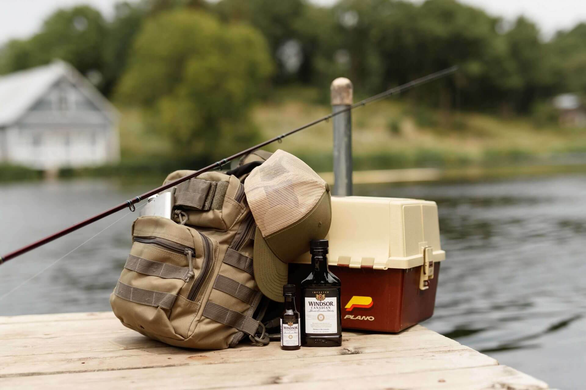 Fishing equipments beside a lake with Windsor shot and a mini bottle