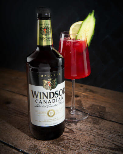 Windsor Canadian Blended Canadian Whisky 1L Bottle and cocktail in wine glass garnished with cucumber and lemon..